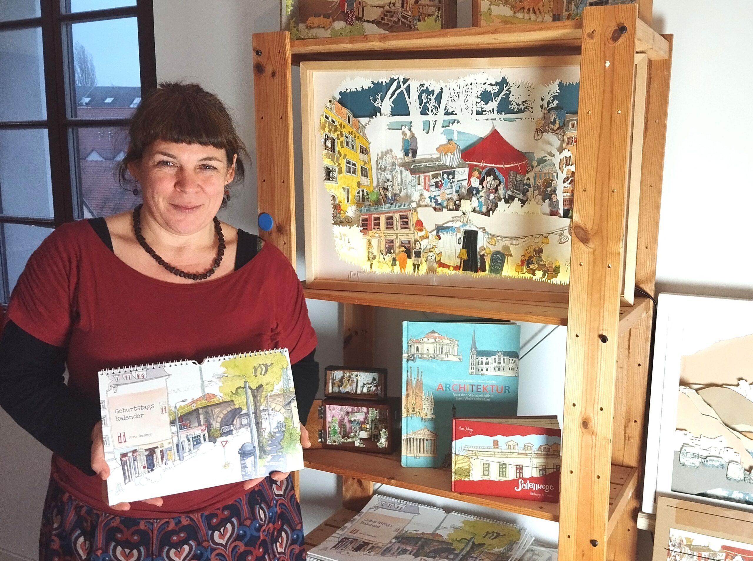 Illustratorin Anne Ibelings, in der Hand den von ihr gestalteten 'Immerwährenden Geburstagskalender'. Dieser kann jedes Jahr wiedergenutzt werden.