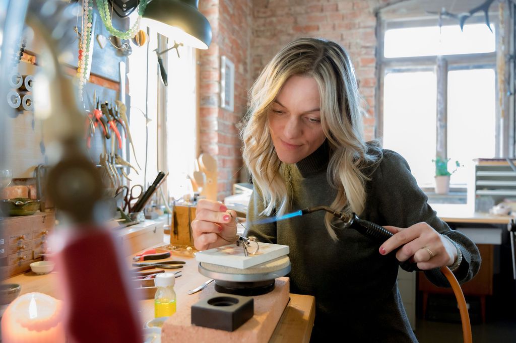 Anna-Maria, vertieft in den Schmiedeprozess. In der runden Vertiefung des Werktisches werden Silber- oder Goldspäne aufgefangen. Foto: Katja Knetschke Fotografie