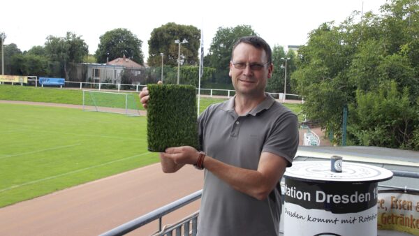 Abteilungsleiter Sportstätten Nico Seidel präsentiert den neuen Kunstrasen. Damit soll der Hartplatz künftig ganzjährig bespielbar werden. Foto: J. Frintert