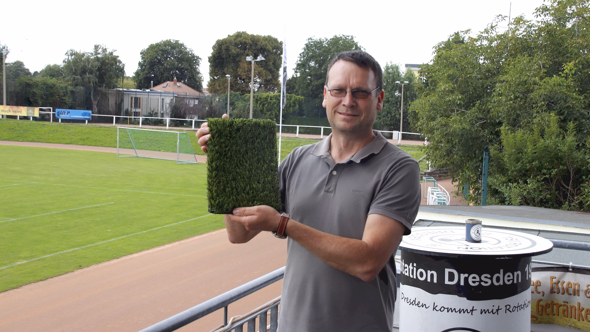 Abteilungsleiter Sportstätten Nico Seidel präsentiert den neuen Kunstrasen. Damit soll der Hartplatz künftig ganzjährig bespielbar werden. Foto: J. Frintert