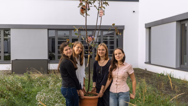 Die vier Schülerinnen aus der zehnten Klassen des Gymnasiums um den Quittenbaum, der bald in dem grünen Innenhof eingepflanzt werden soll. Von links nach Rechts: Matilda Sonntag, Smilla Chwalczyk, Merle Rottmann und Marita Hamann. Foto: Sebastian Diehl.